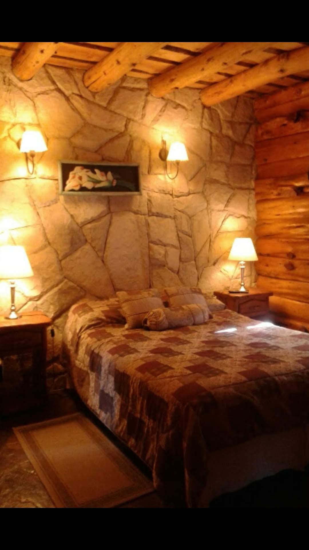Dormitorio cálido con pared de piedra